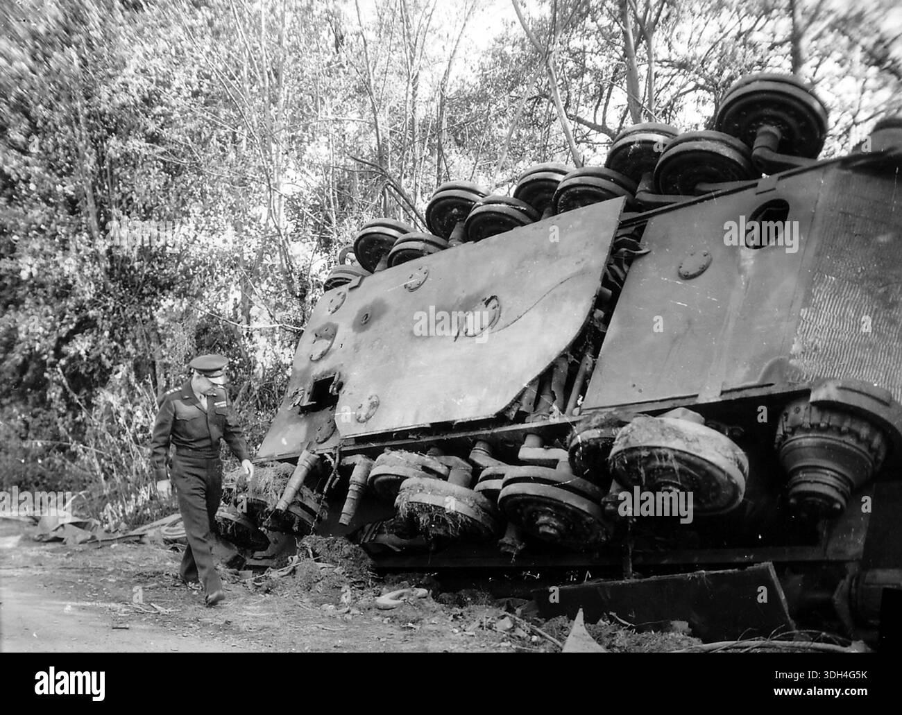 Il generale Eisenhower sta guardando un carro Tiger II distrutto dopo la cattura di Falaise. Il gruppo d'armate tedesco B fu catturato e circondato intorno alla città di Falaise. La feroce battaglia portò alla distruzione del gruppo d'armate tedesco. Il 6 giugno 1944 un'enorme forza d'invasione Alllied che coinvolgeva 7000 navi e 140.000 uomini sbarcò con successo sulla costa francese e stabilì cinque teste di spiaggia. Una campagna di inganno di successo significò che gran parte della resistenza tedesca si trovava a Calais e le perdite furono relativamente poche per le dimensioni e i rischi dell'operazione. Foto Stock