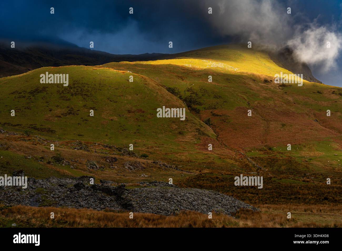Soleggiata collina sotto nuvole basse e luce spettacolare in Snowdonia Foto Stock
