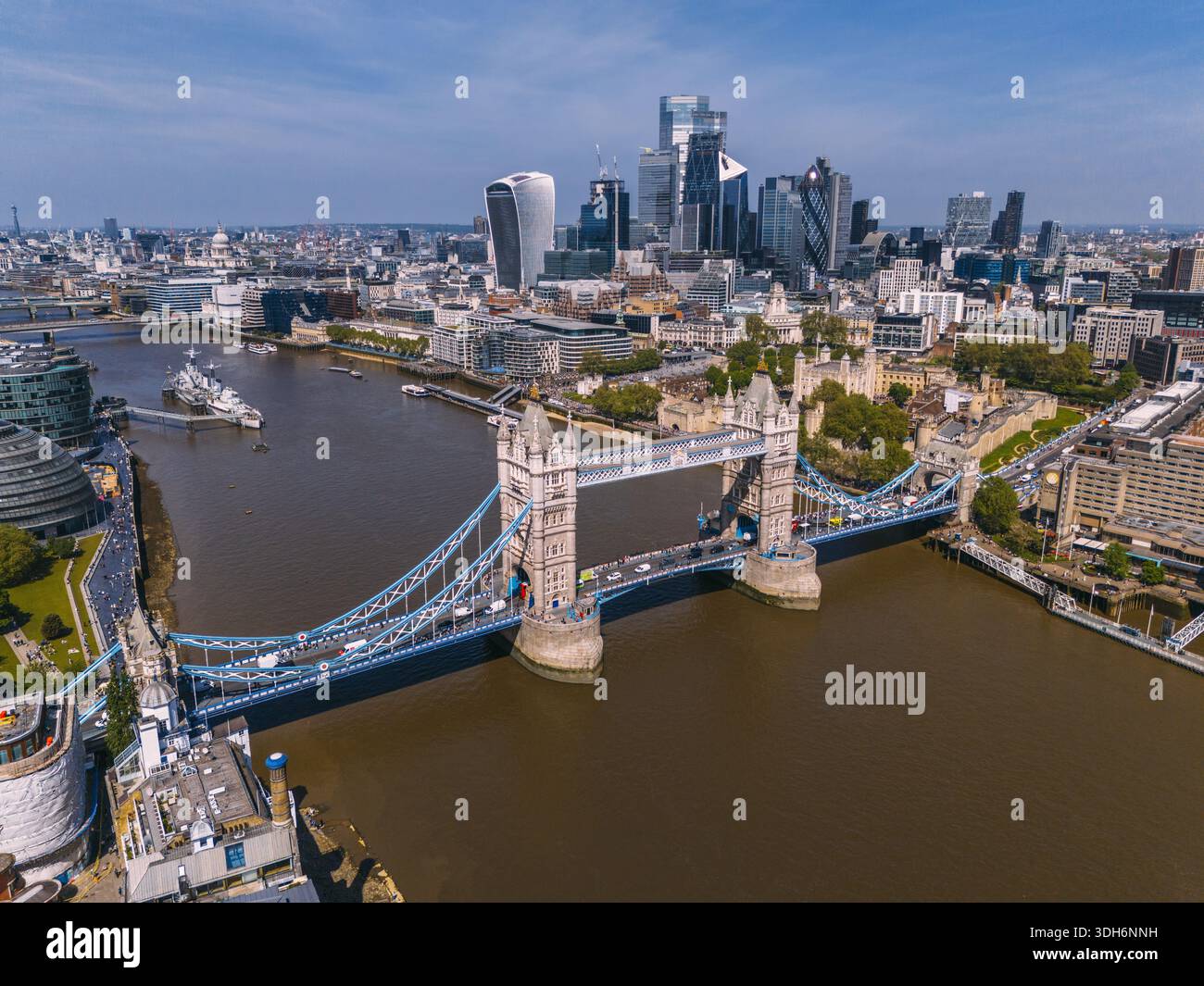 Vista aerea dell'iconico Tower Bridge che attraversa il tranquillo Tamigi, incorniciato dai moderni grattacieli dello skyline di Londra, Londra, Greater London, uni Foto Stock