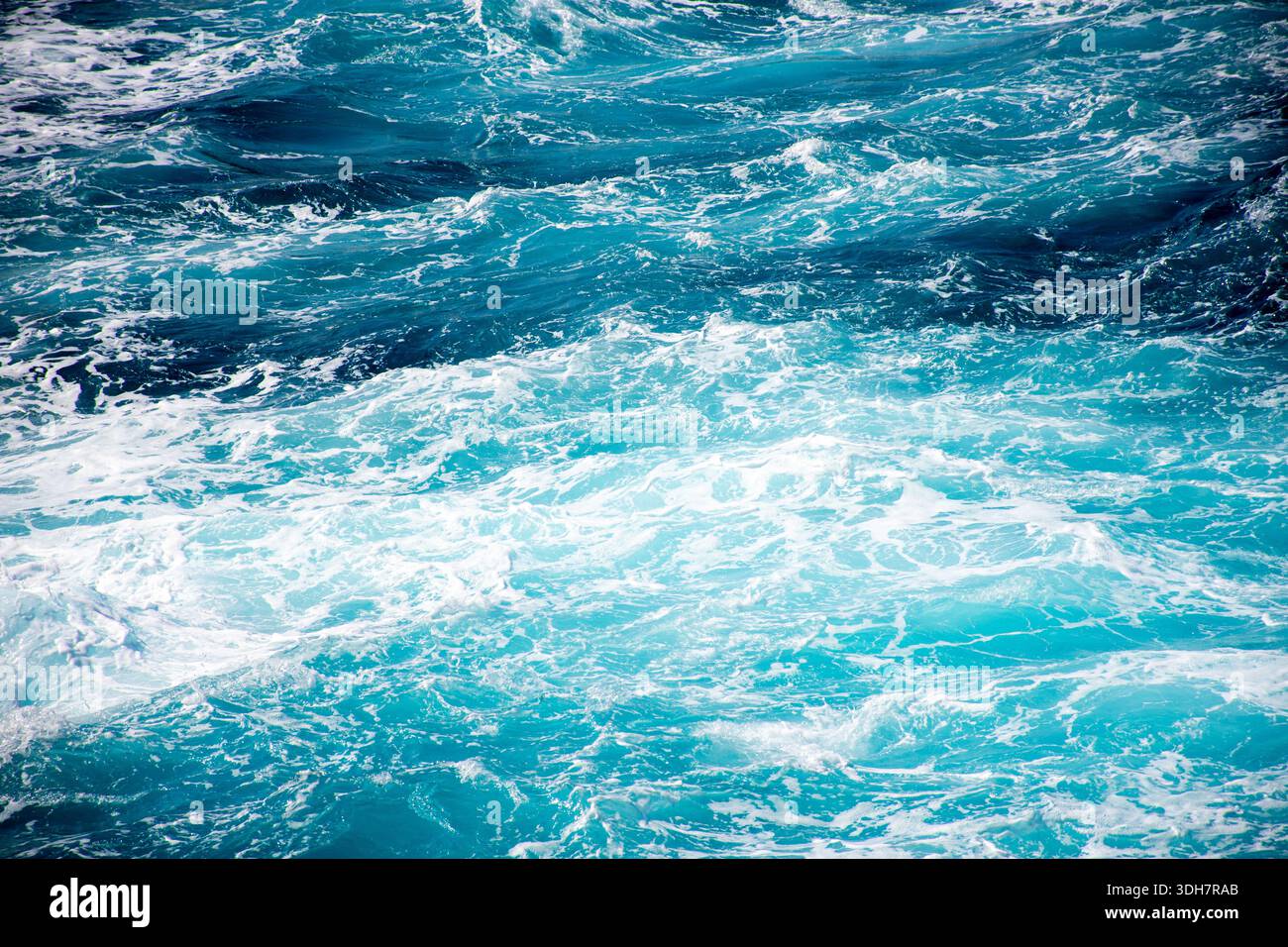 Primo piano delle onde turchesi dell'oceano con schiuma bianca in movimento Foto Stock