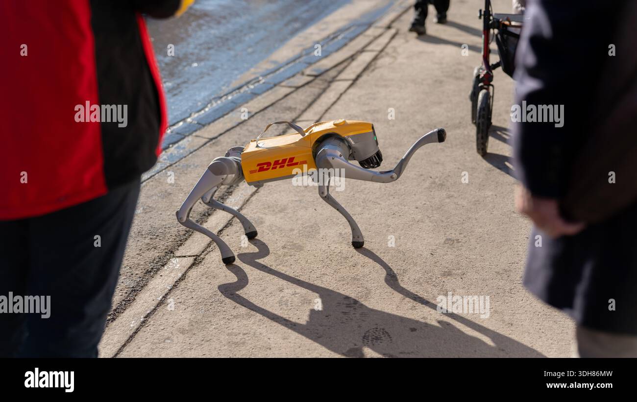 Cane robot con il logo di un'azienda di logistica che cammina su un marciapiede, dimostrando la consegna futura Foto Stock