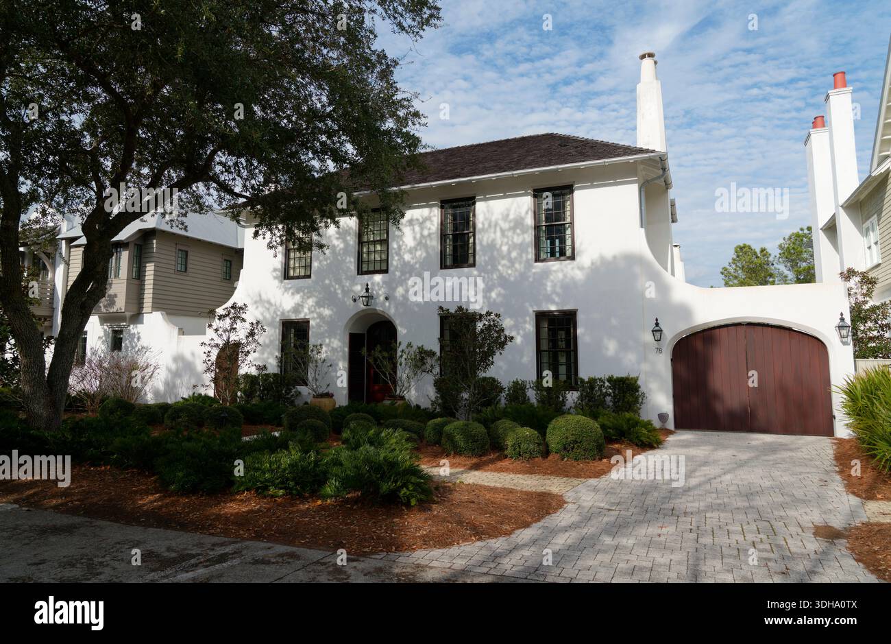 Casa costiera bianca in stile mediterraneo con giardino paesaggistico in un quartiere residenziale in Florida, Stati Uniti. Foto Stock