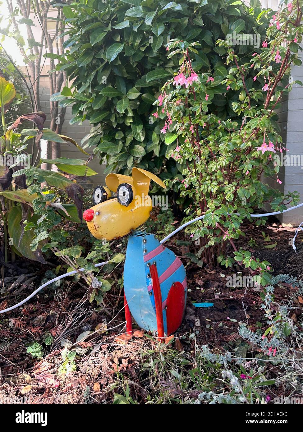 Stravagante scultura di cani in metallo in giardino Foto Stock