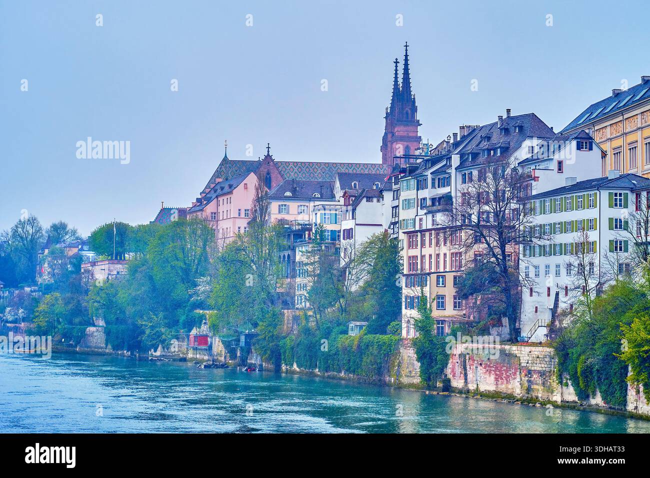 La vista sulla riva del fiume Reno con storiche case residenziali e guglie di Basilea Minster sullo sfondo, Svizzera Foto Stock