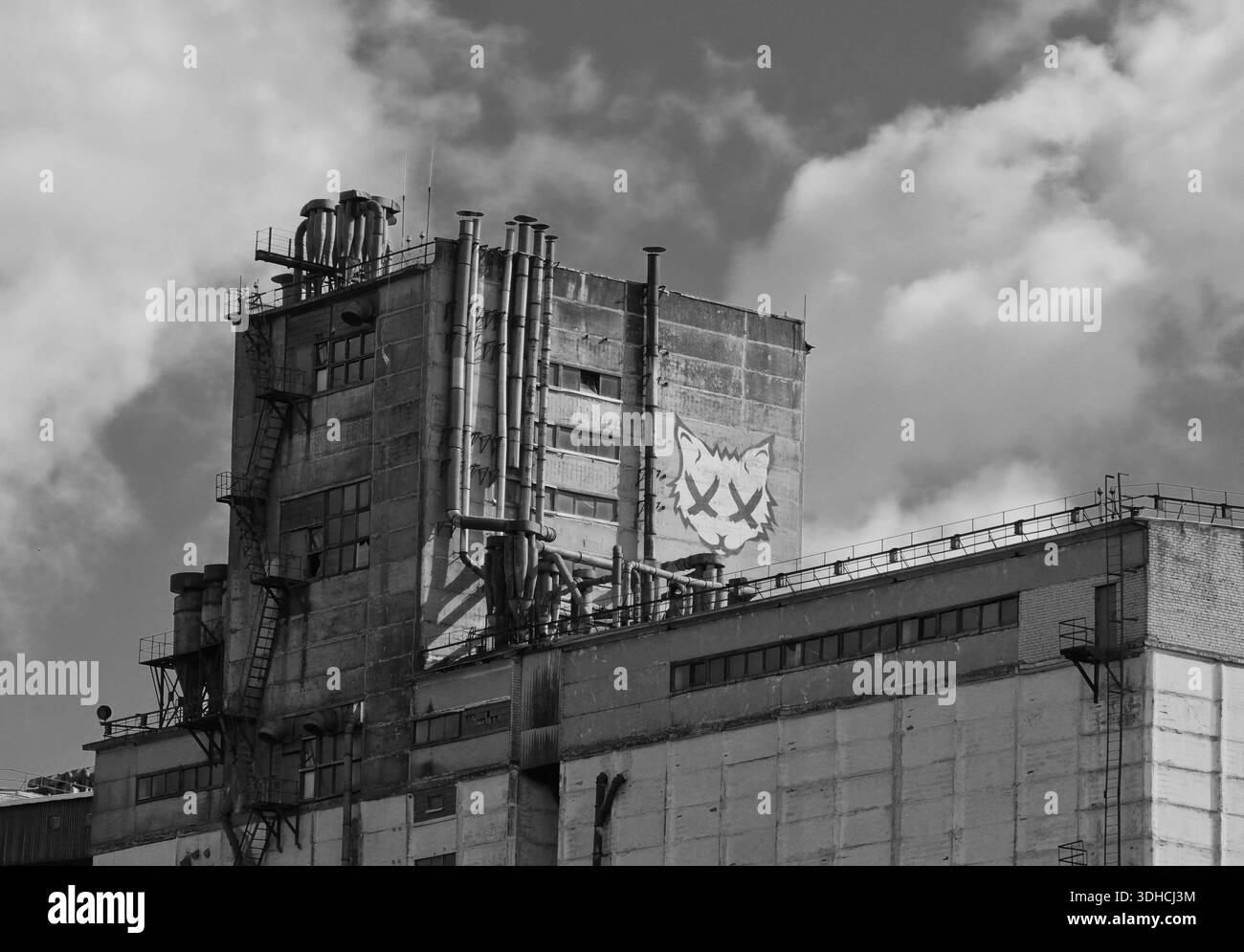 Edificio industriale con graffiti nel porto di riga, bianco e nero Foto Stock