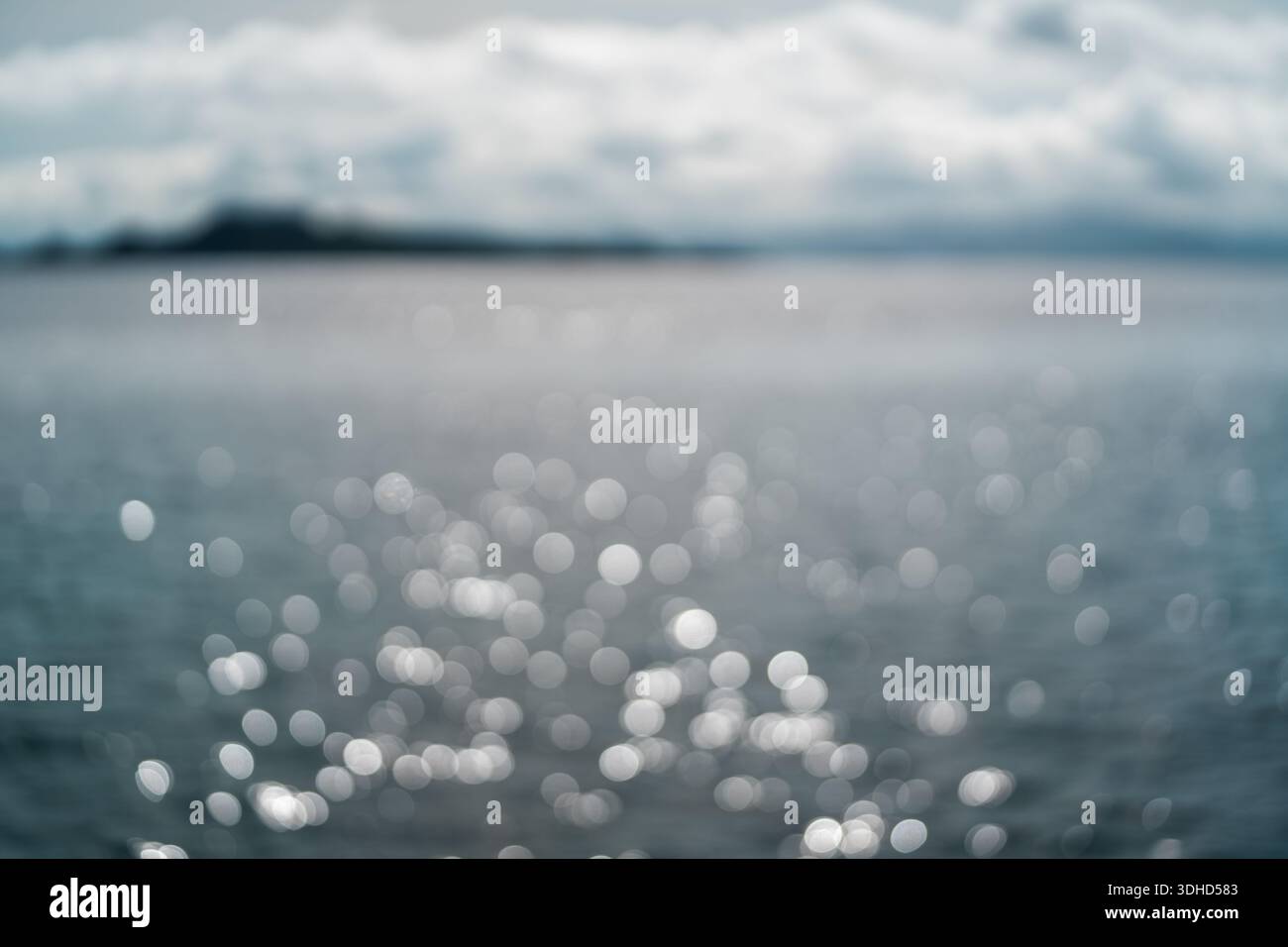 Sfondo bokeh astratto di luce solare scintillante sull'acqua dell'Oceano Foto Stock