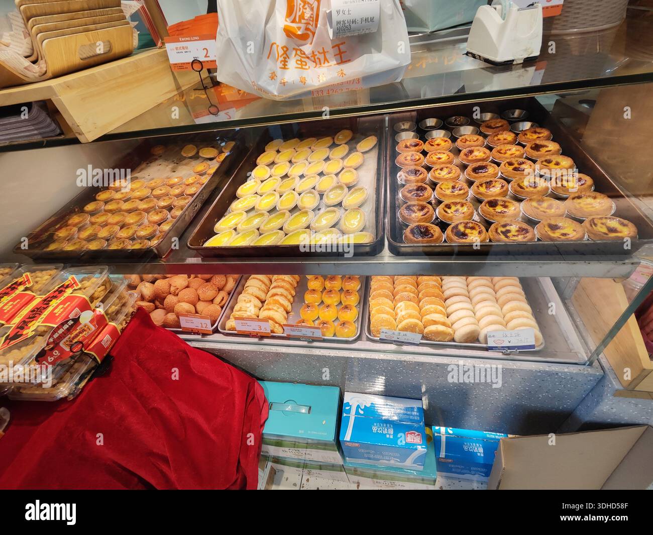 Dolci appena sfornati e dessert esposti in una vetrina di prodotti da forno Foto Stock