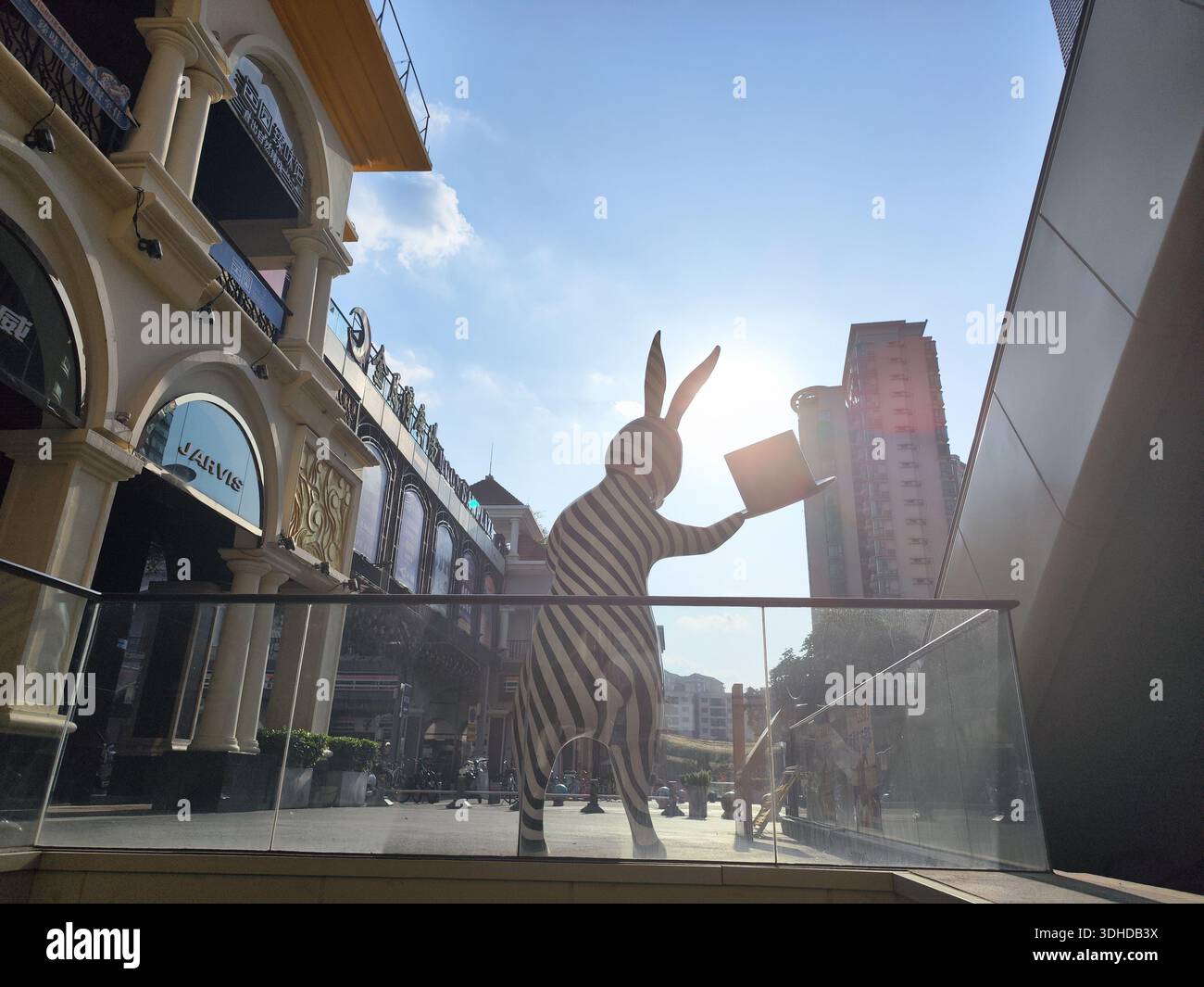 Gigante scultura di coniglio a strisce zebrate che tiene un libro nel quartiere dello shopping urbano Foto Stock