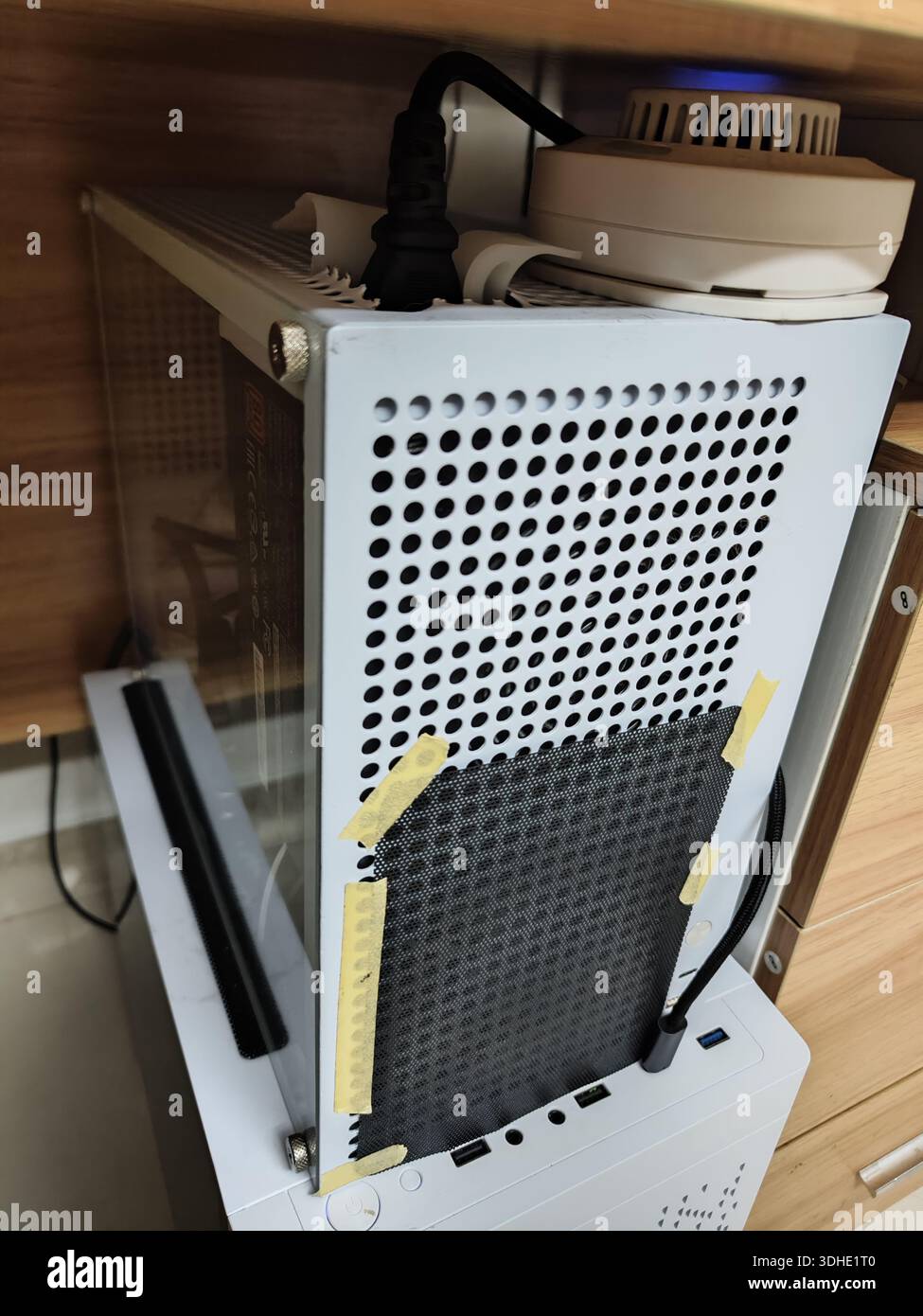 Console Xbox serie S con configurazione di raffreddamento personalizzata sotto una scrivania Foto Stock