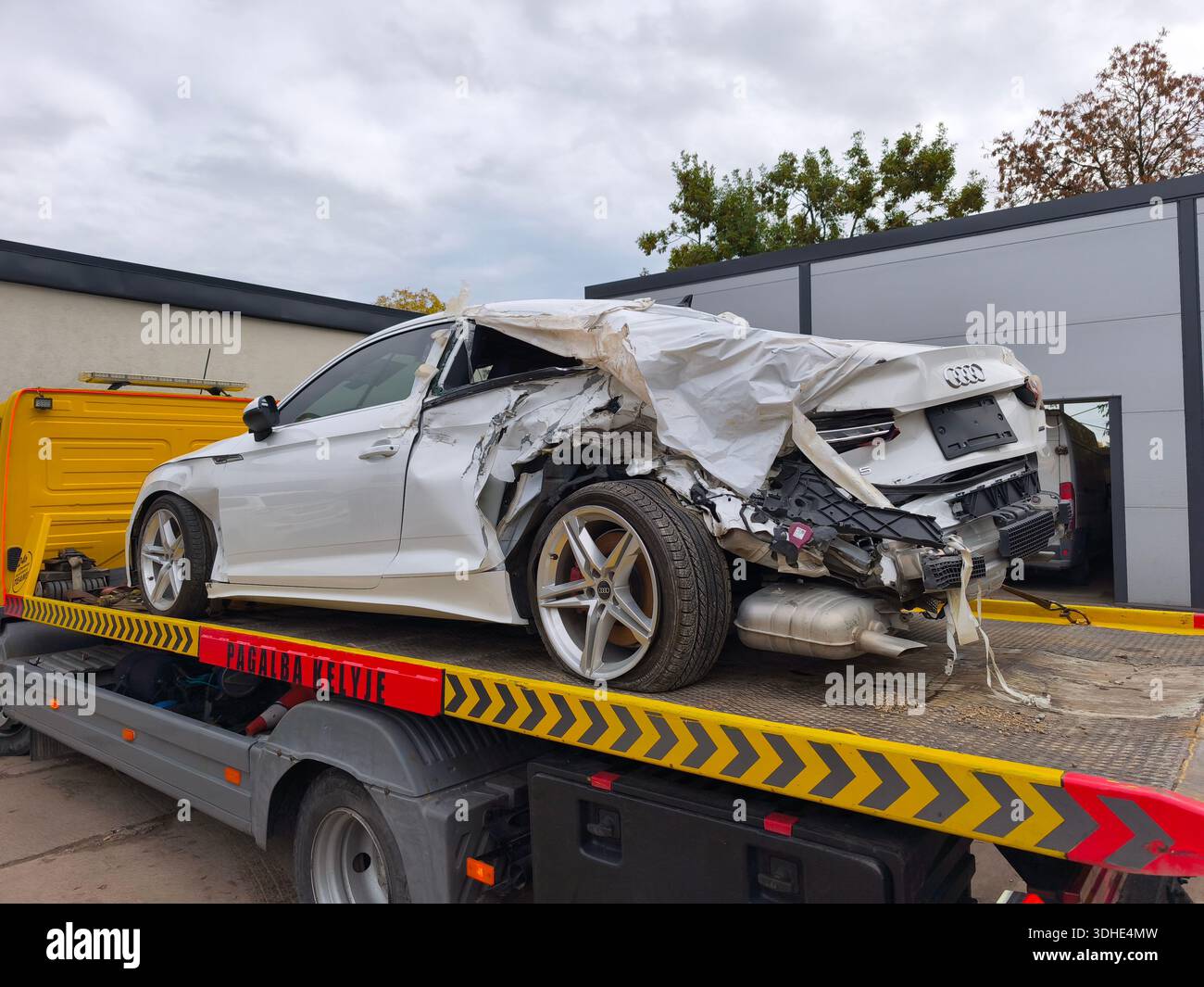 Vilnius, Lituania - 2025-10-06 - servizio di trasporto veicoli dopo incidente con auto Audi totale su rimorchio vicino al servizio auto Foto Stock
