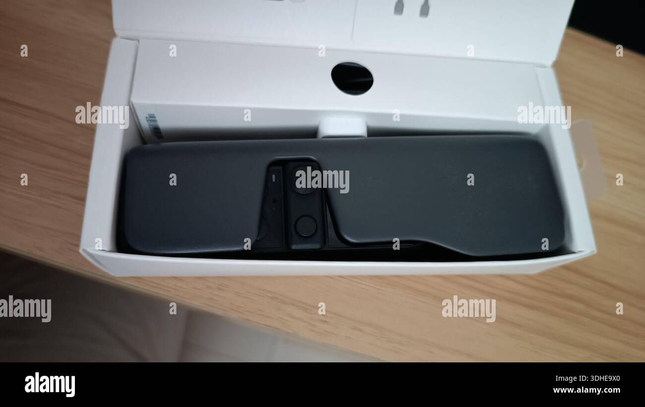 Action camera compatta in scatola su una superficie in legno Foto Stock