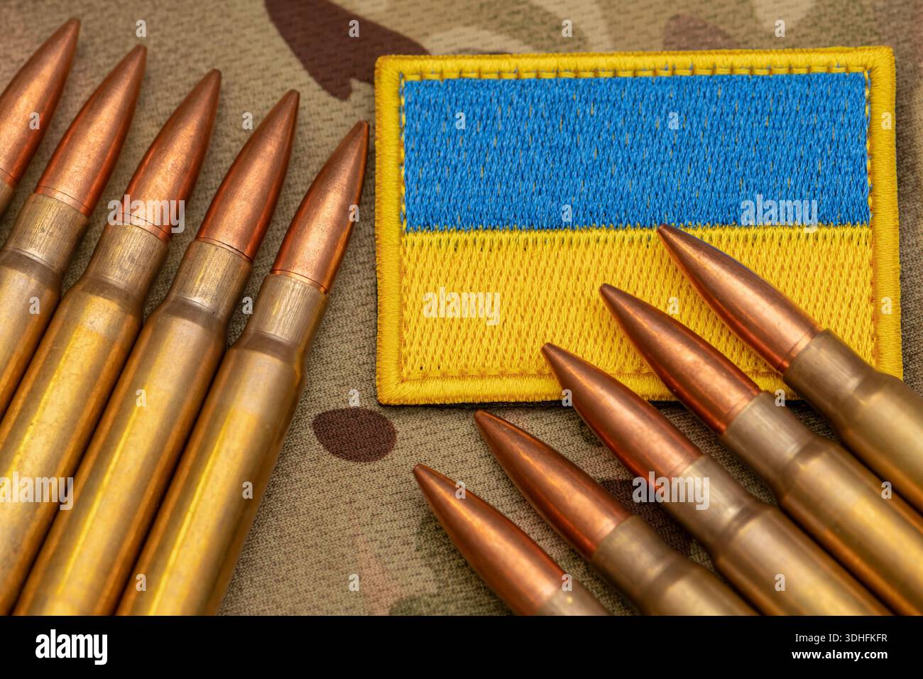 Patch di bandiera Ucraina e munizioni poste su tessuto mimetico militare Foto Stock