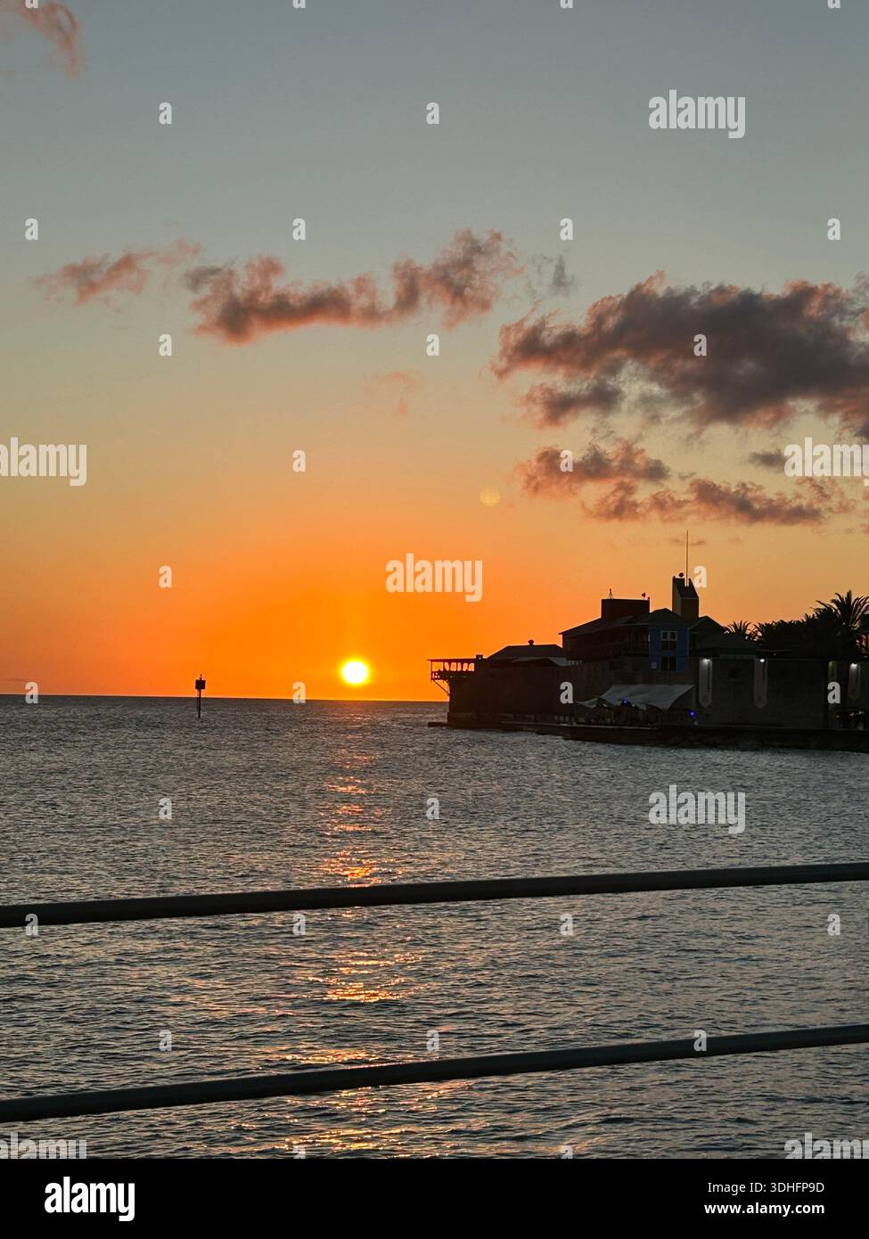 Tramonto sull'oceano con acque calme e molo - Immagine stock catturata con smartphone