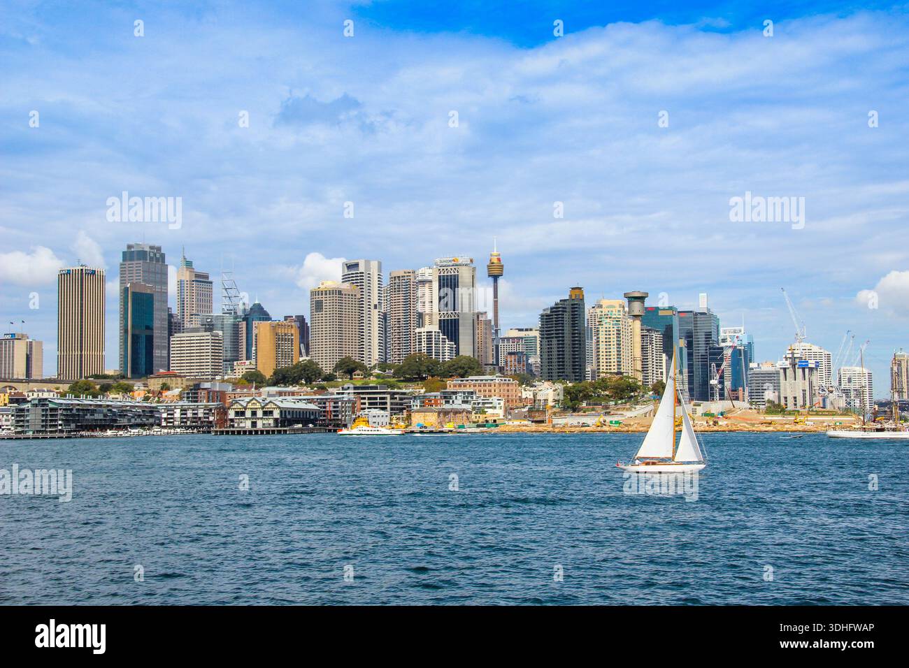 Yacht in viaggio con il paesaggio urbano del CBD di Sydney sullo sfondo. Foto Stock
