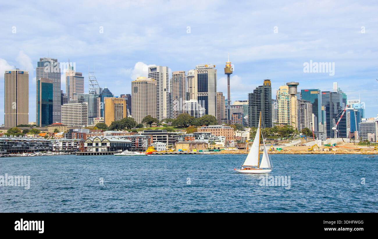 Yacht in viaggio con il paesaggio urbano del CBD di Sydney sullo sfondo. Foto Stock