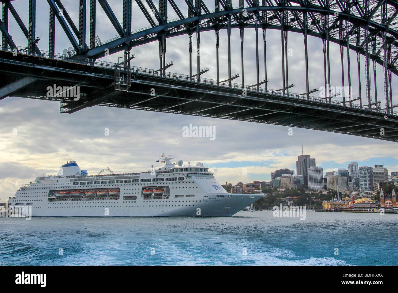 Grande nave da crociera che passa sotto il Sydney Harbour Bridge Foto Stock