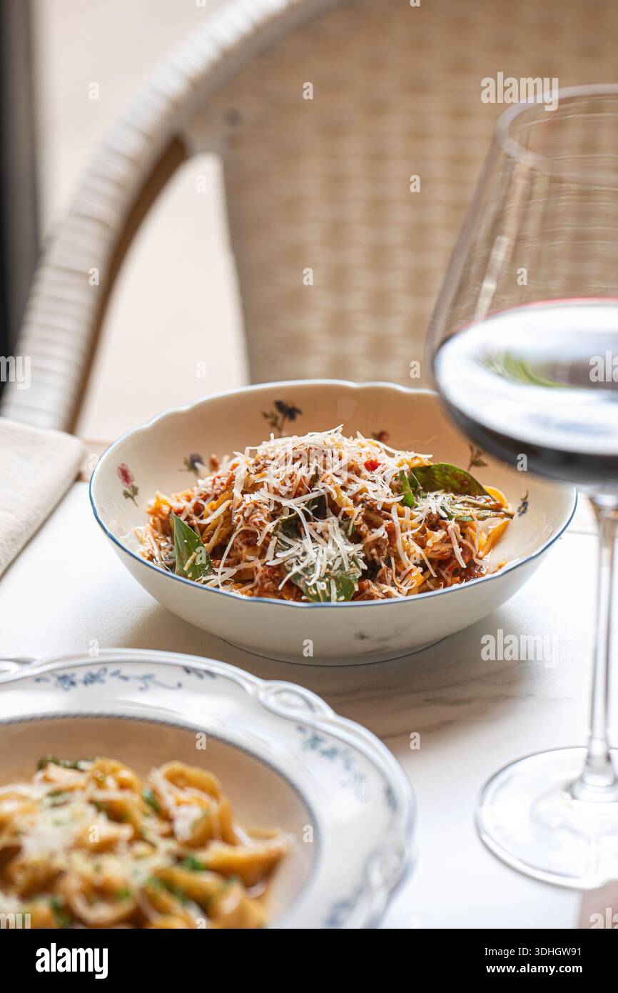 Spaghetti bolognesi serviti con vino rosso Foto Stock