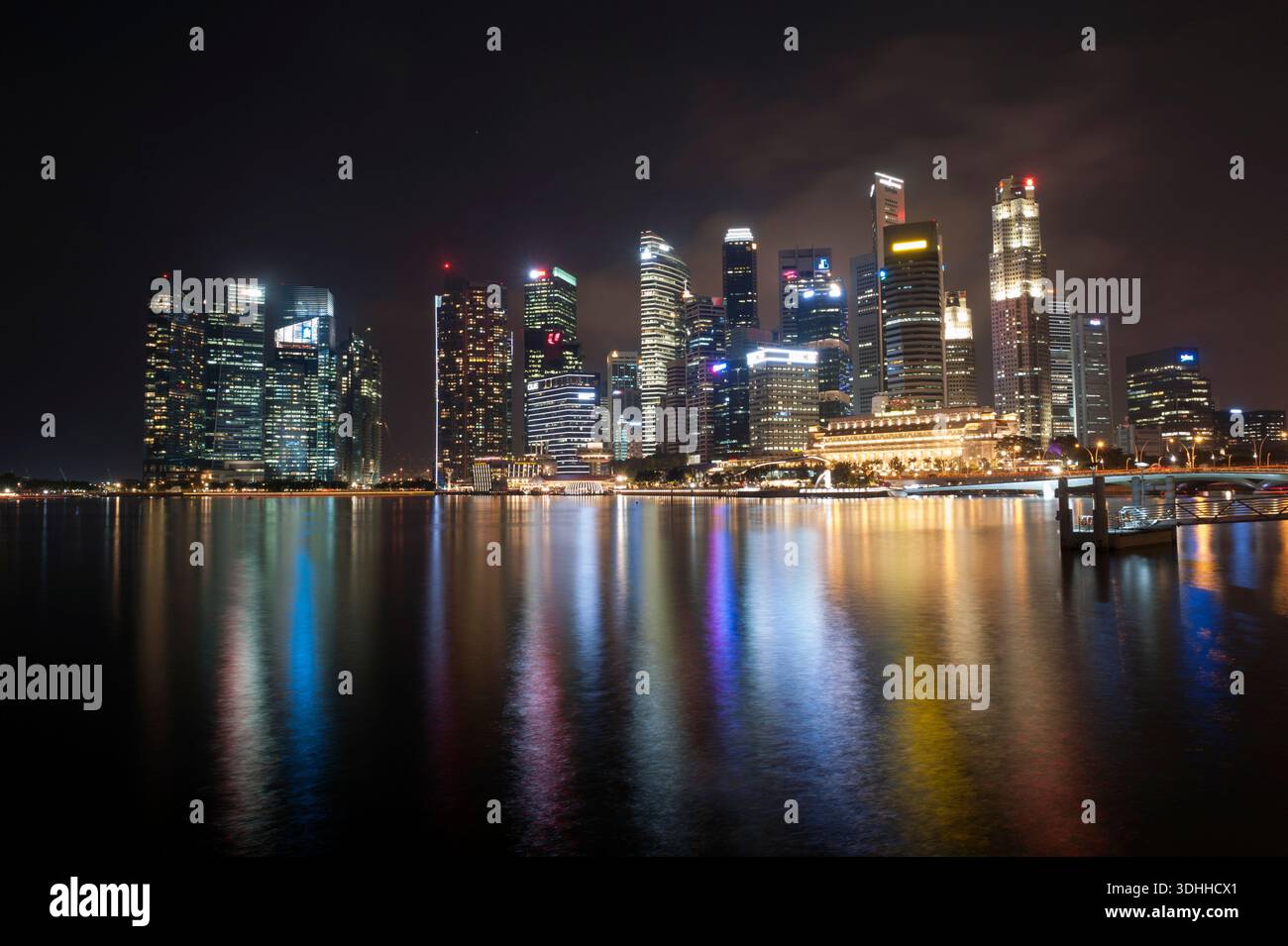 Singapore grattacieli del quartiere degli affari si riflette nel fiume Singapore di notte. Foto Stock