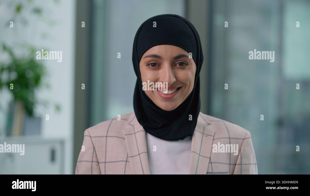 Ritratto in ufficio felice sorridente toothy araba etnica musulmana donna d'affari che guarda la macchina fotografica sorridere spensierata indiano islamica imprenditrice soddisfatta Foto Stock