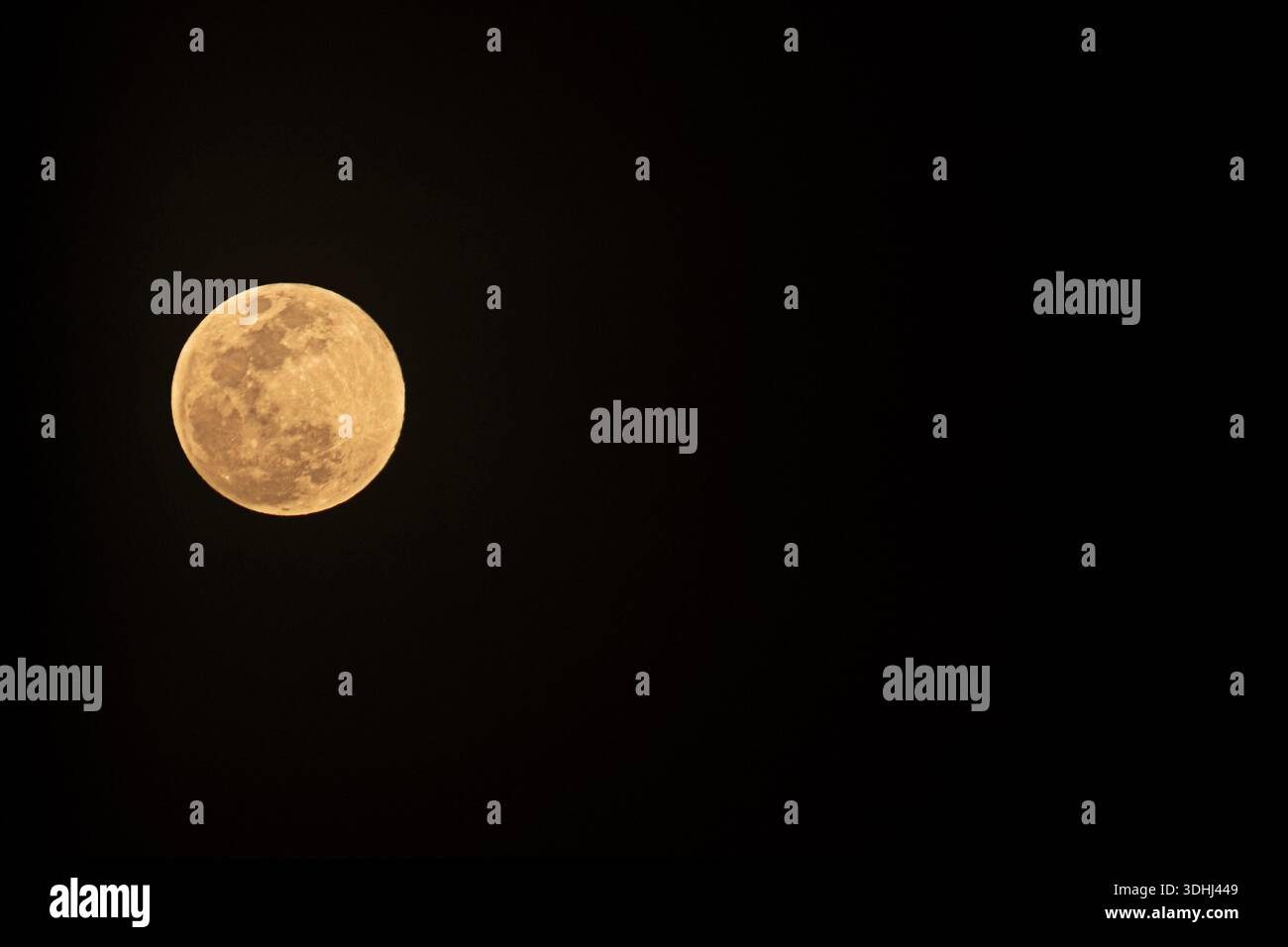 Luna piena che brilla nel cielo notturno buio Foto Stock