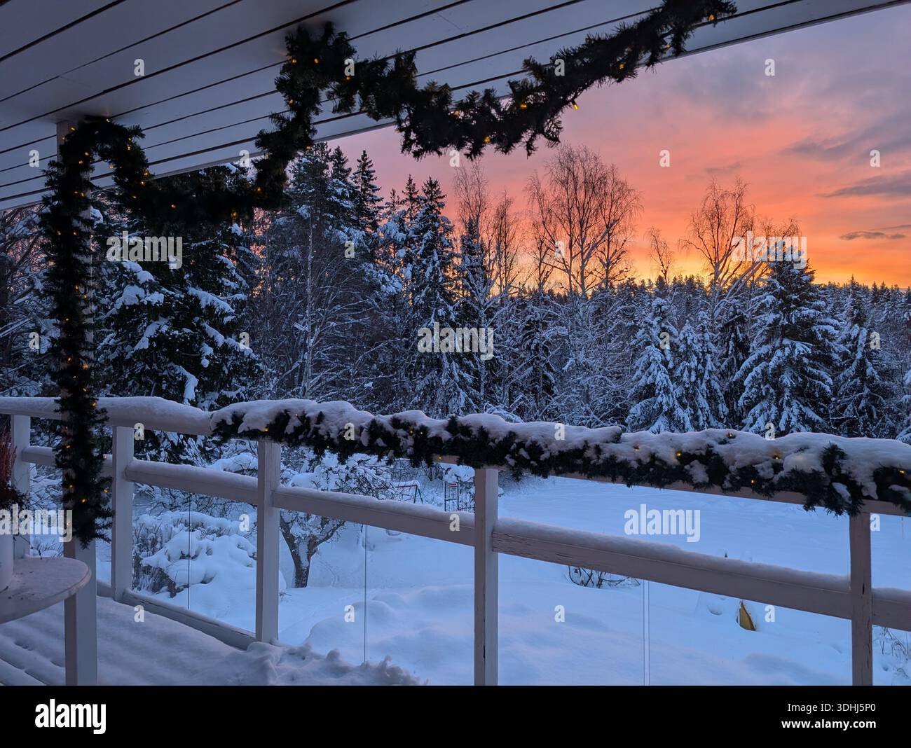 Veranda bianca in legno ricoperta di neve con recinzione in vetro. Colori molto luminosi nel cielo questo pomeriggio invernale in Scandinavia. Google Pixel 9 Pro XL - Immagine stock catturata con smartphone