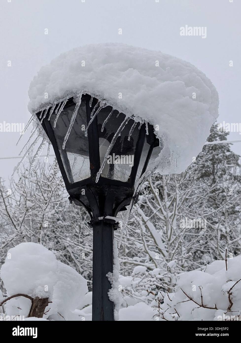La lampada perde la sua pesante calotta da neve decorata dalla natura stessa con ghiaccio. Google Pixel 9 Pro XL Foto Stock