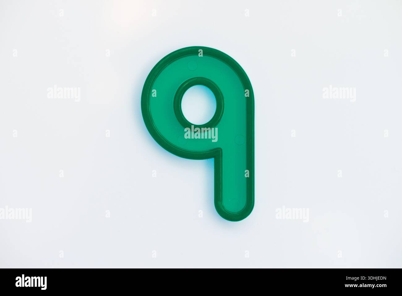 Una plastica verde numero nove su sfondo bianco Foto Stock