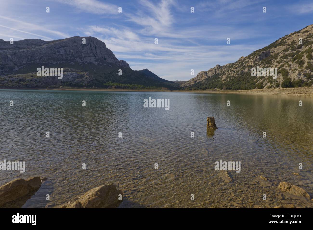 Pietre sul litorale del bacino idrico di Cúber nelle montagne della Serra de Tramuntana, Maiorca, sotto un cielo blu con nuvole. Foto Stock