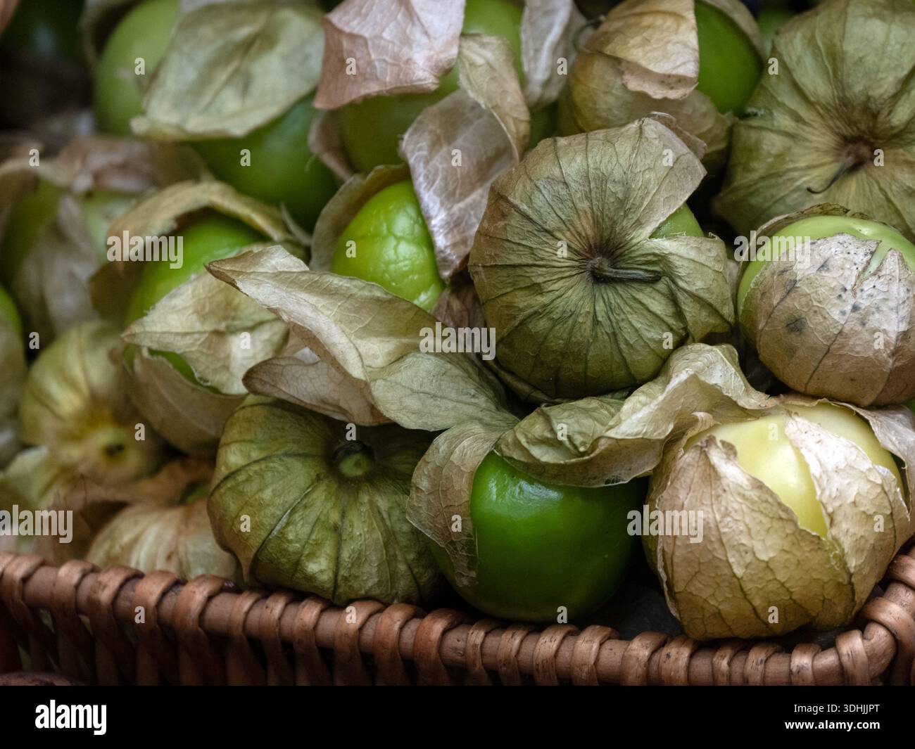Primo piano di Tomatillos freschi crudi in un cestino in un mercato alimentare Foto Stock