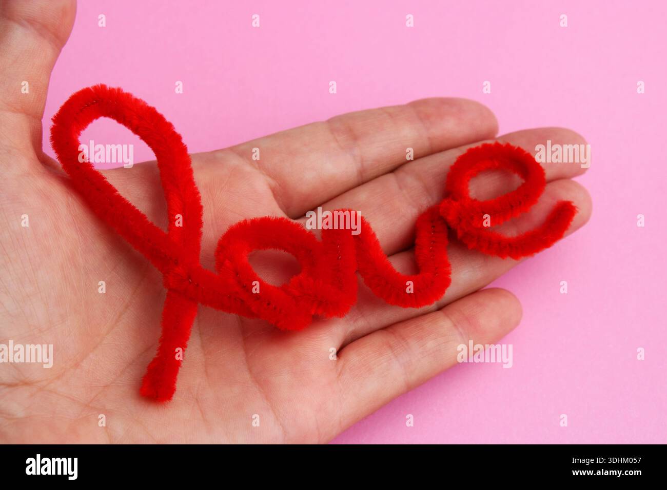 Mano che tiene la parola "amore" Foto Stock