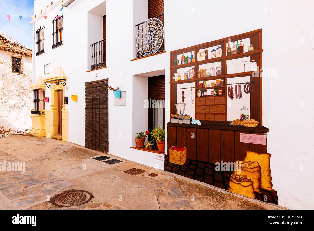 Strada e murale - "The Grocer's Shop". Cartajima, Málaga, Andalucía, Spagna, Europa Foto Stock
