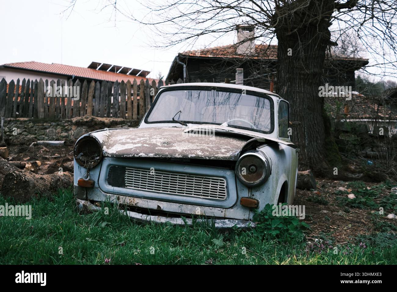 Una vecchia Trabant quasi a pezzi, parcheggiata davanti a una casa in un villaggio bulgaro Foto Stock