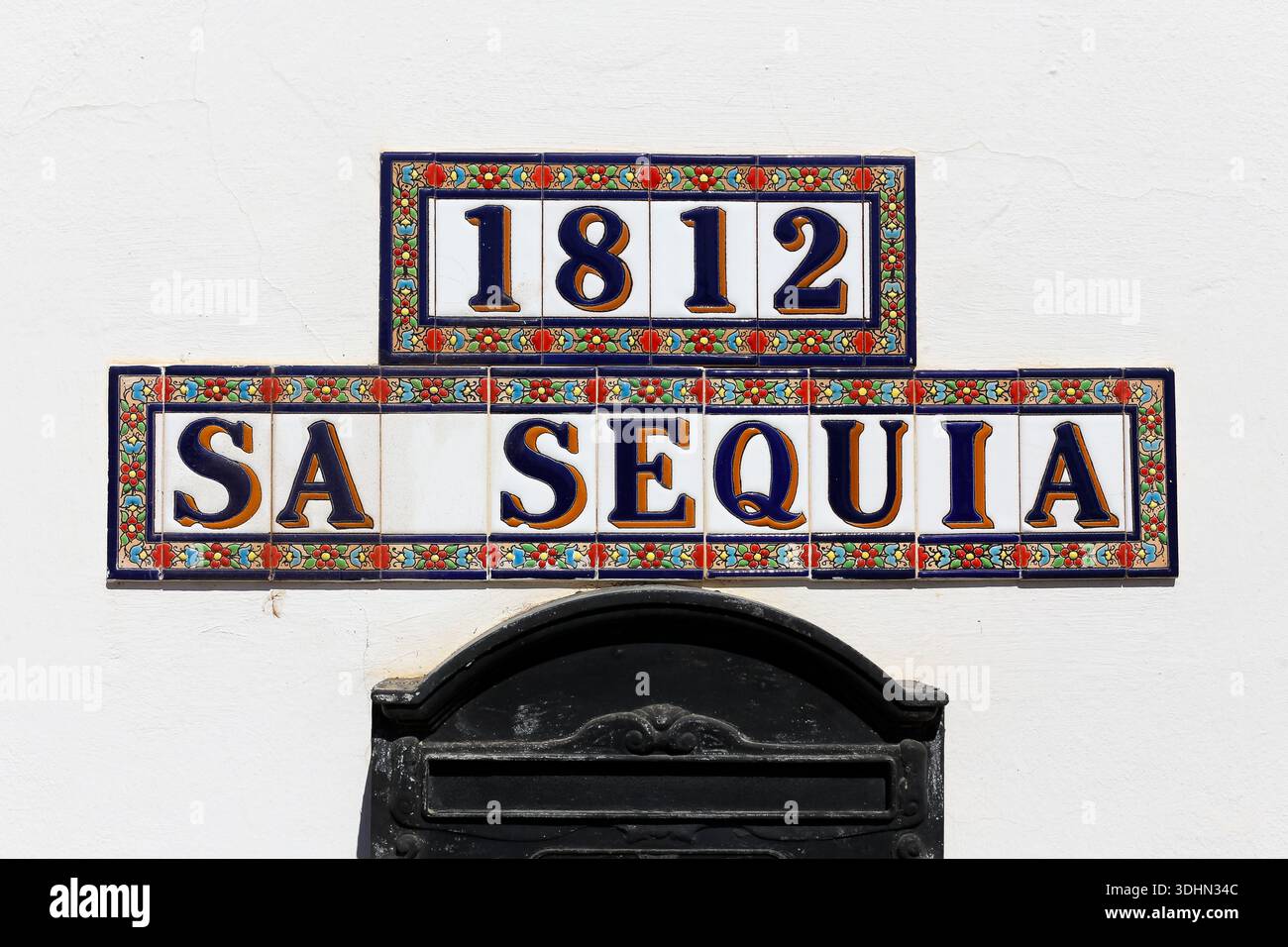 Tradizionale cartello stradale in ceramica con la scritta "sa Sequia 1812" su un muro bianco a Ibiza, Isole Baleari, Spagna. Foto Stock