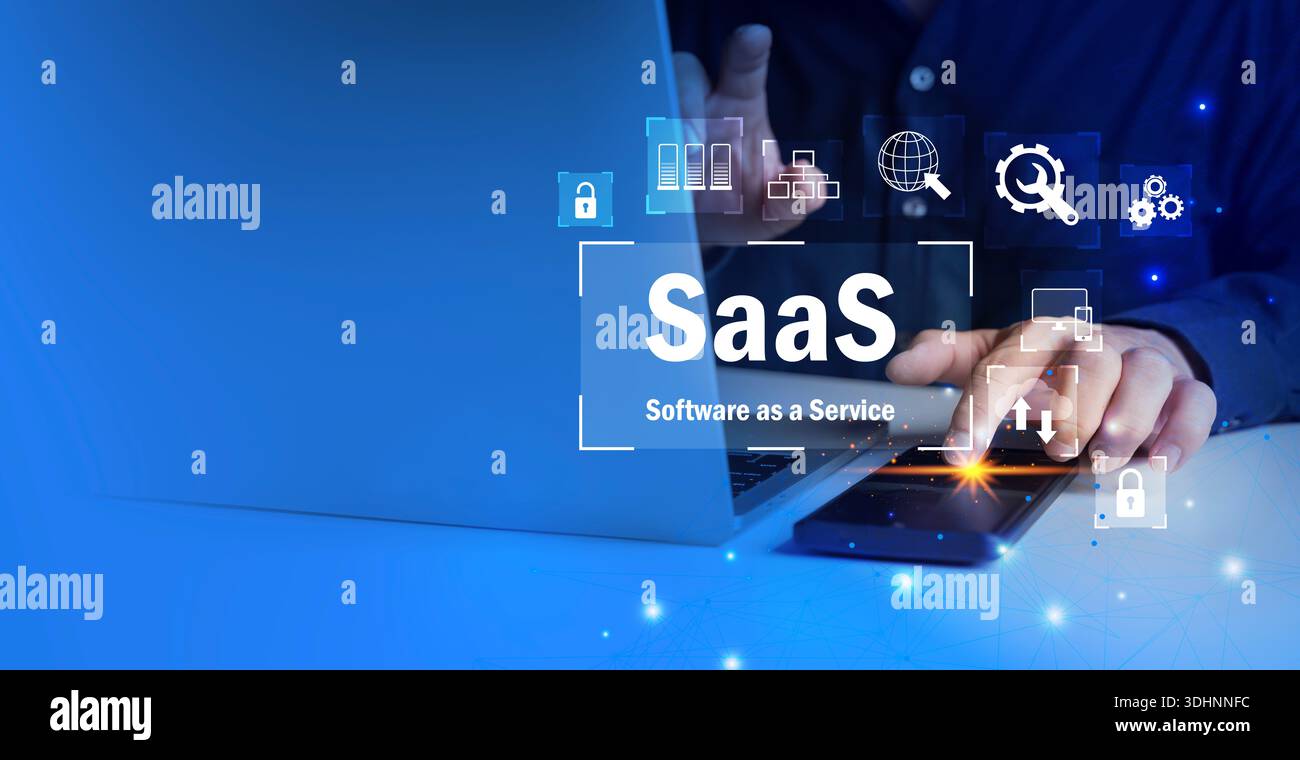 Uomo d'affari che utilizza laptop e smartphone con testo SaaS e icone digitali, che rappresentano il cloud computing, le piattaforme in abbonamento, Foto Stock