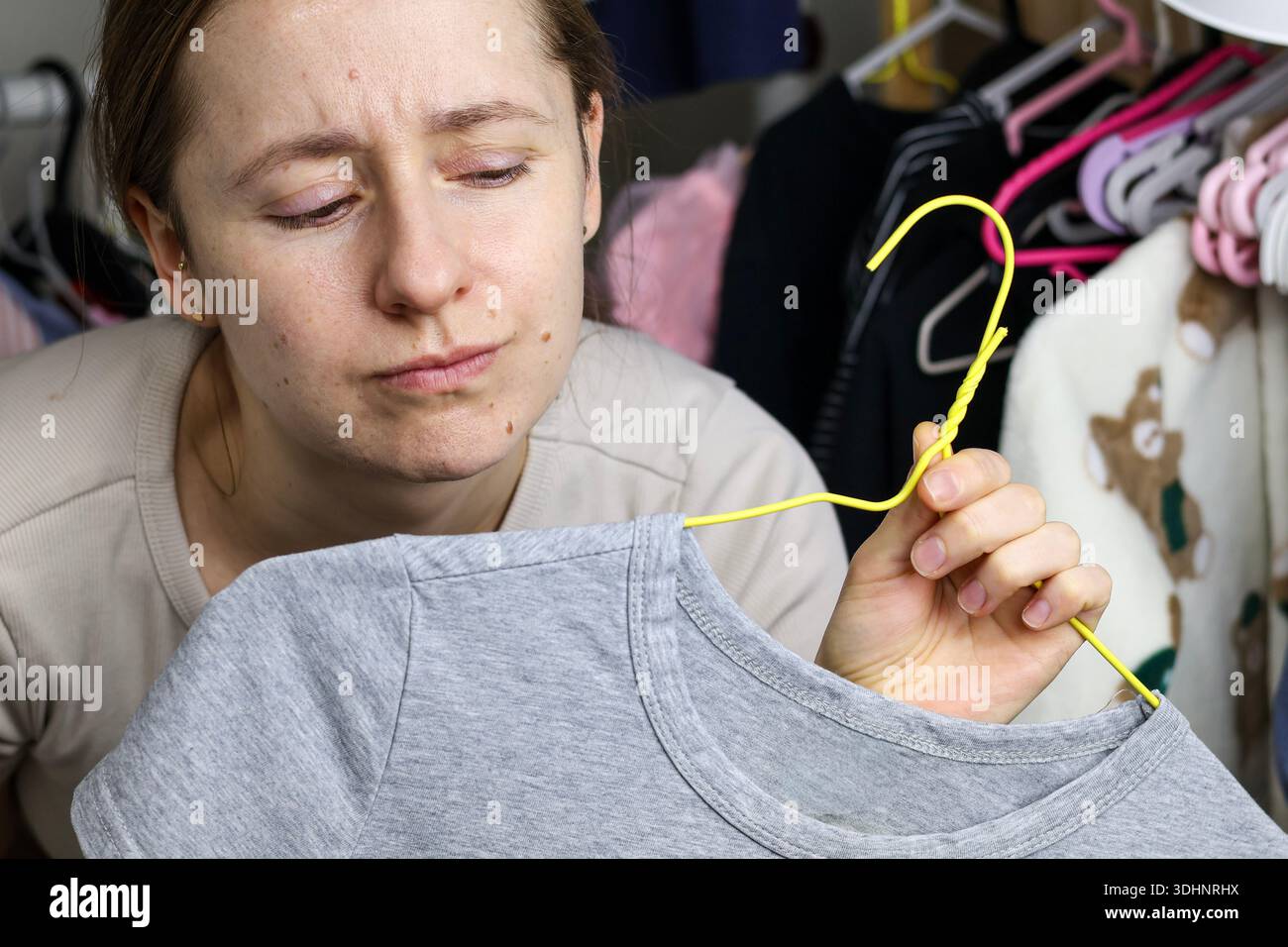 Seoul, Corea del Sud — Janiary 23, 2026: Una donna guarda un capo di abbigliamento mentre si trova vicino a un guardaroba a casa Foto Stock