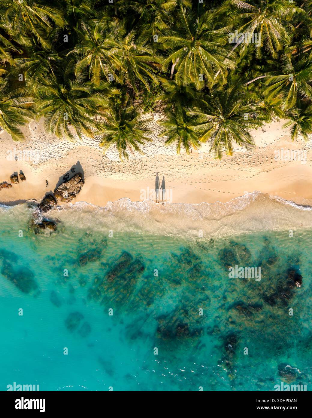 Scopri la bellezza della spiaggia di Takhian a Koh Kood, Thailandia, con le sue morbide spiagge sabbiose e le acque cristalline. Una coppia in vacanza camminando sulla Foto Stock