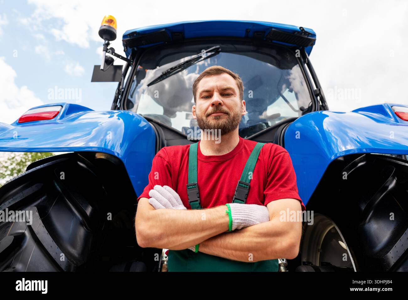 Meccanico dell'attrezzatura agricola maschile per trattore nell'azienda agricola Foto Stock