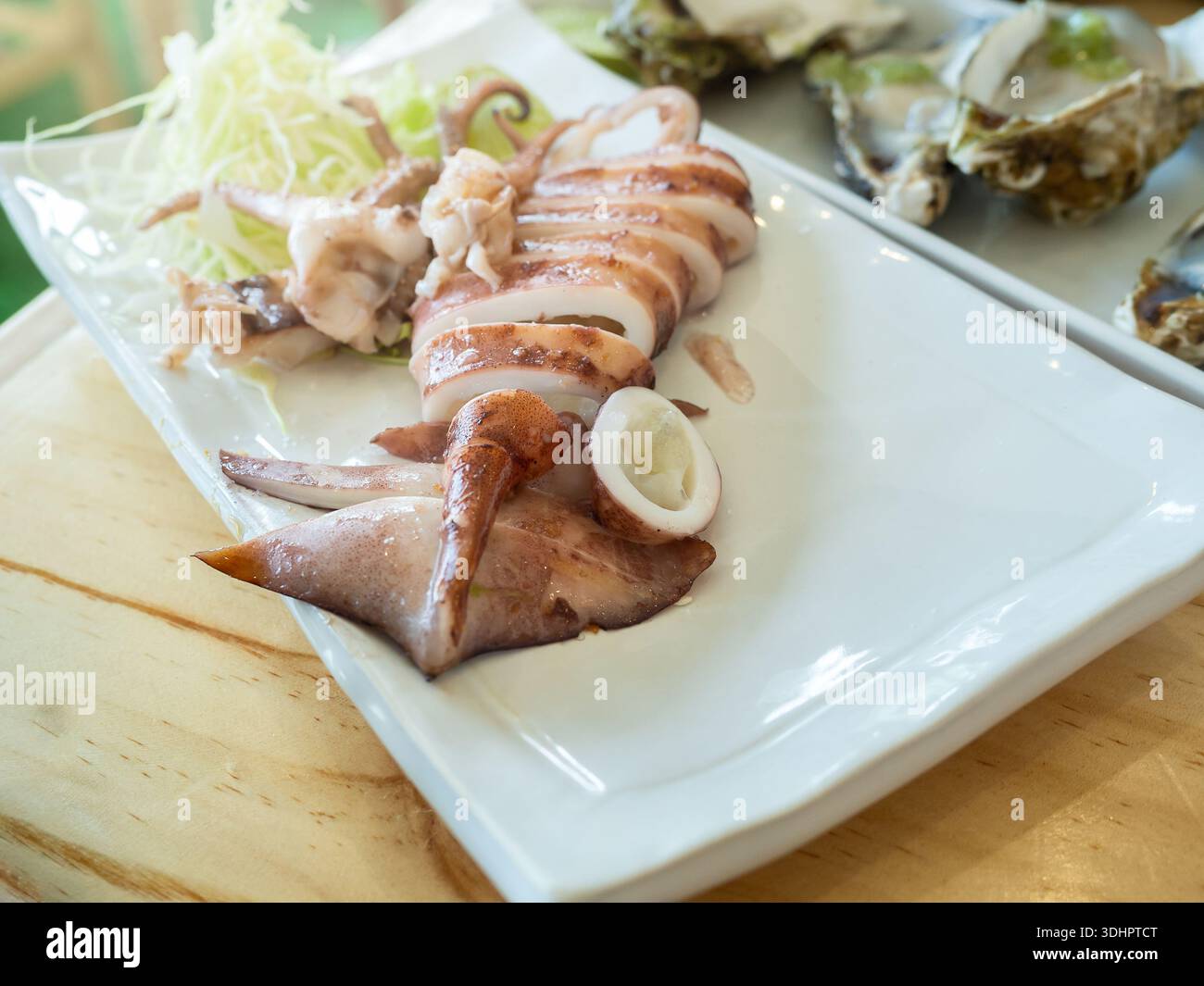 IKA yaki (liquido alla griglia) su piatto bianco, calamari marinati cotti a fette. Cibo giapponese. Foto Stock