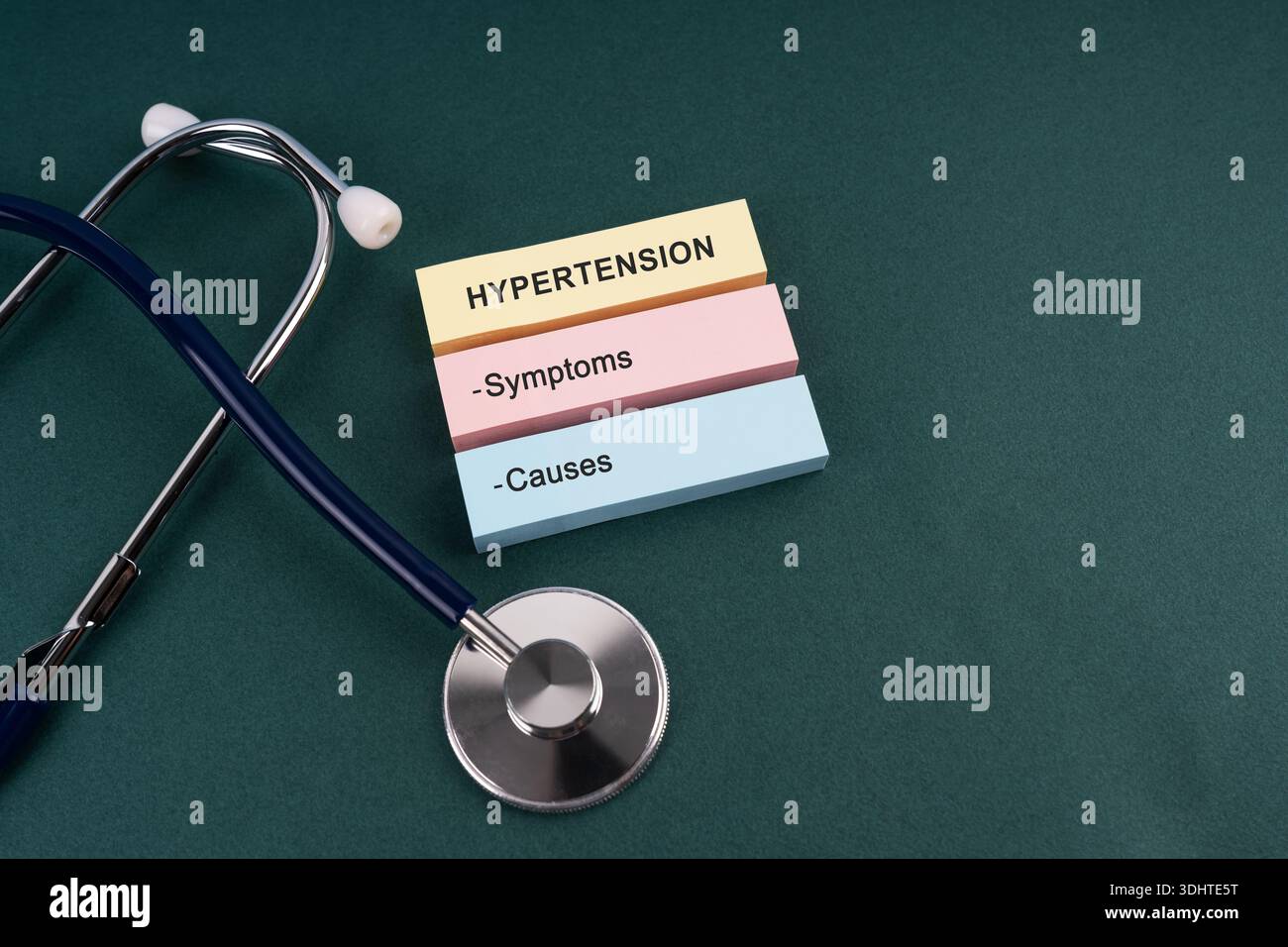 Stetoscopio e ipertensione sintomi e cause testo su carta nota concetto medico Foto Stock