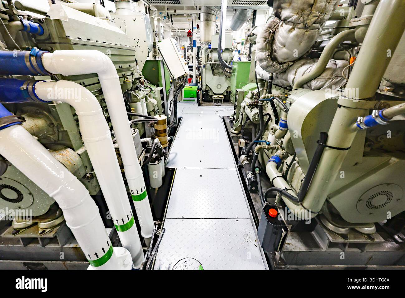 Sala macchine per navi industriali interna con motori diesel marini, tubi e macchinari, corridoio tecnico all'interno del locale macchine per navi Foto Stock