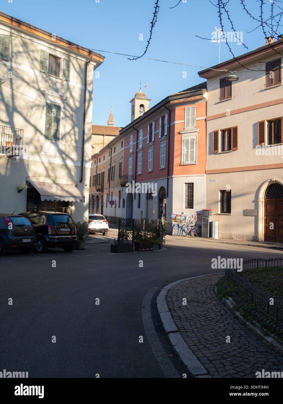 Cremona, Italia 8 gennaio 2026 pittoresca scena di strada a Cremona, Italia, bagnata dalla luce del sole, che presenta un'architettura affascinante e una lontana campana Foto Stock