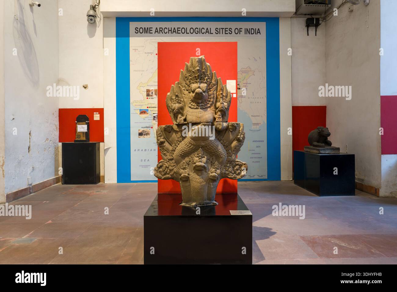 Calcutta, India - 24 marzo 2024: Una grande scultura in pietra è esposta su un piedistallo di fronte a una mostra muraria intitolata "alcuni siti archeologici dell'India", con reperti aggiuntivi e pannelli informativi visibili nella galleria del Museo indiano. Foto Stock