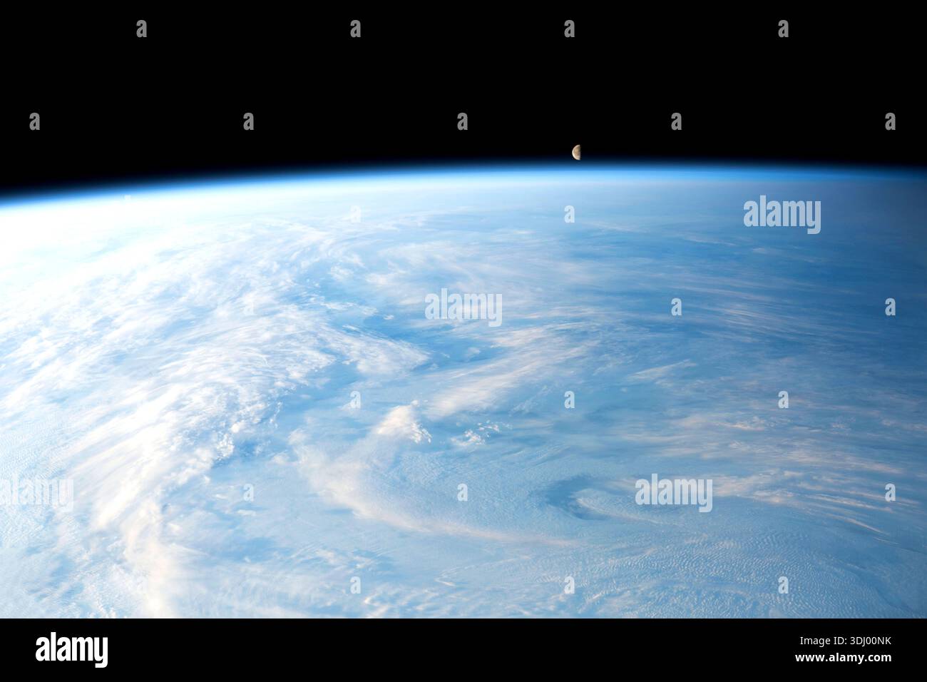 La luna gibbosa in declino è raffigurata appena sopra l'orizzonte della Terra in questa fotografia della stazione spaziale Internazionale, orbitata a 262 miglia sopra un'Asia centrale nuvolosa. Una fotografia scattata dalla stazione spaziale Internazionale il 4 dicembre 2023. Una versione ottimizzata di un'immagine originale della NASA: Credito: NASA/JMoghbeli Foto Stock