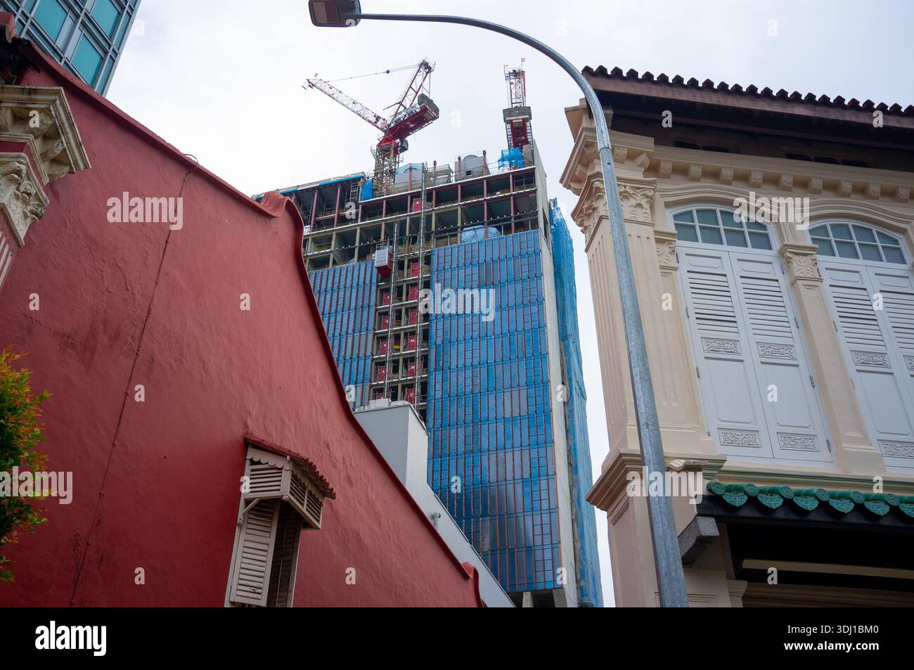 Lavori di costruzione di un nuovo e alto edificio a Emerald Link visto dalla collina Emerald con negozi in primo piano. Foto Stock