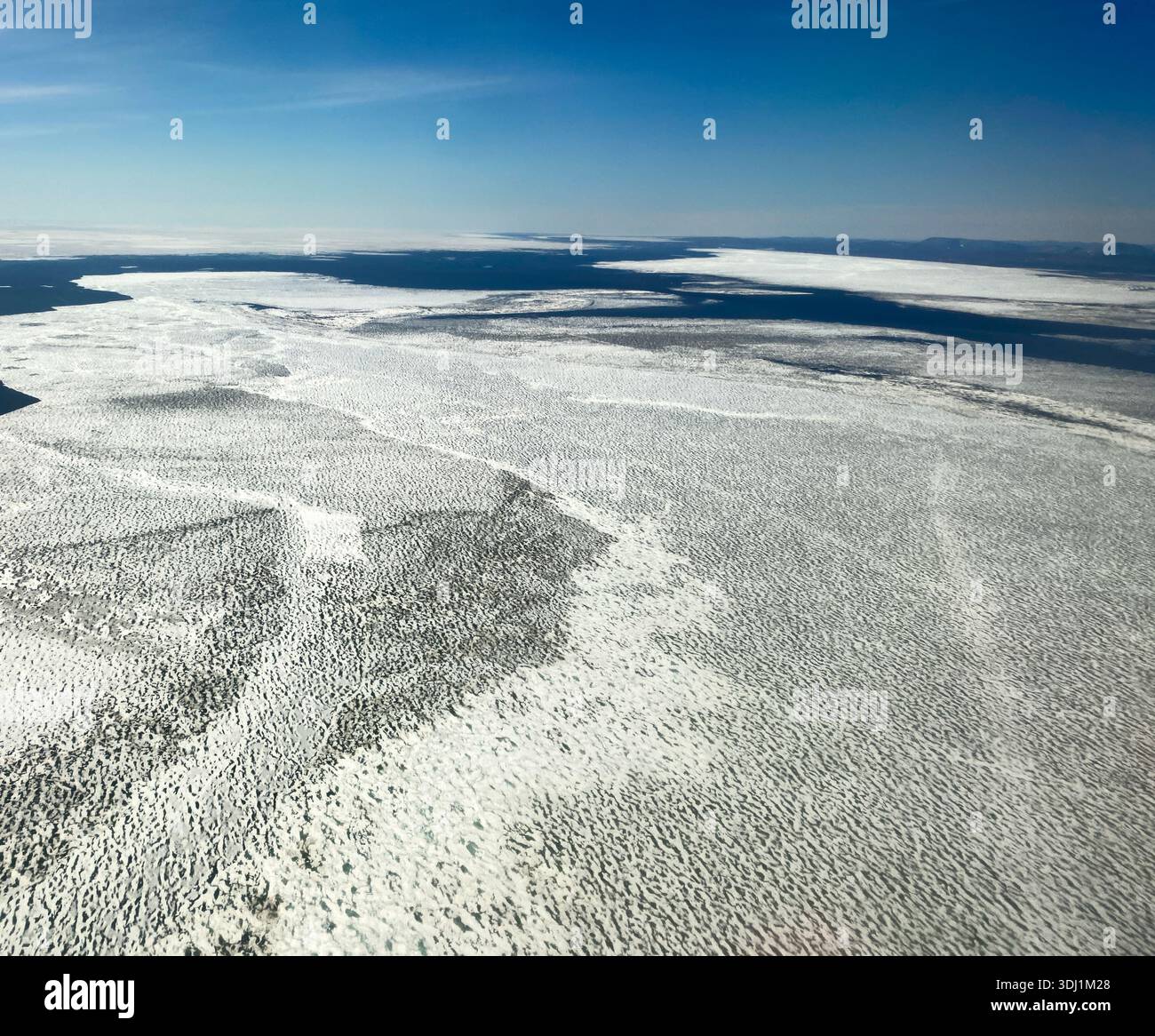 Scongelamento e fratturazione del ghiaccio marino durante la rottura annuale nel Mare di Bering tra nome e la città artica di Kotebue, Alaska - Immagine stock catturata con smartphone