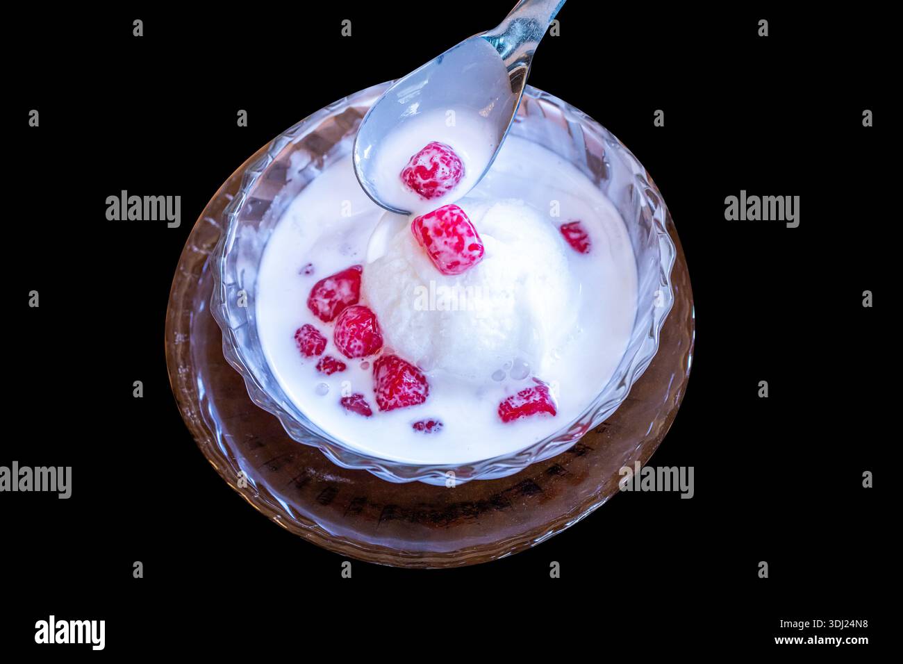 Tagliate a pezzi di castagne d'acqua croccanti e gelatina di cocco nel latte di cocco dolce su un isolato nero. Foto Stock