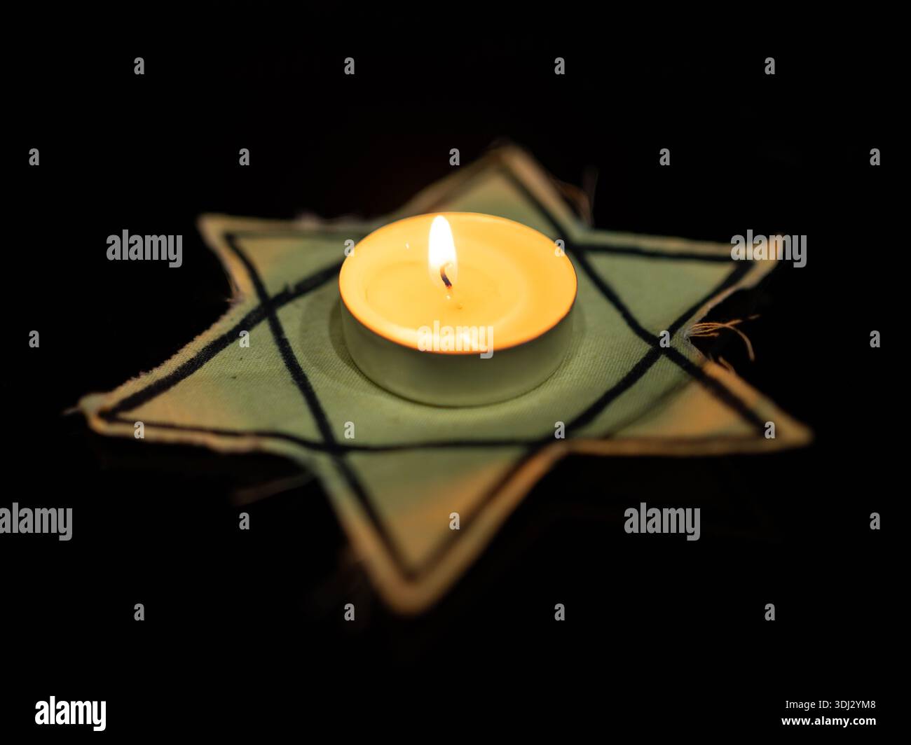 Giornata della memoria delle vittime della Shoah che bruciano nella notte candela e un simbolo della stella ebraica di Davide Foto Stock