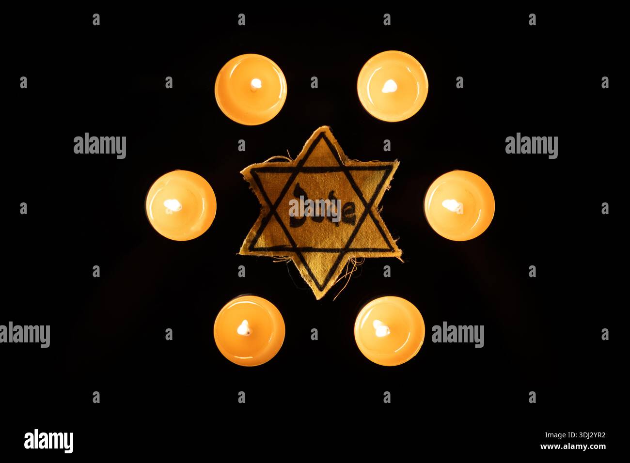 Giornata della memoria delle vittime della Shoah che bruciano nella notte candela e un simbolo della stella ebraica di Davide Foto Stock