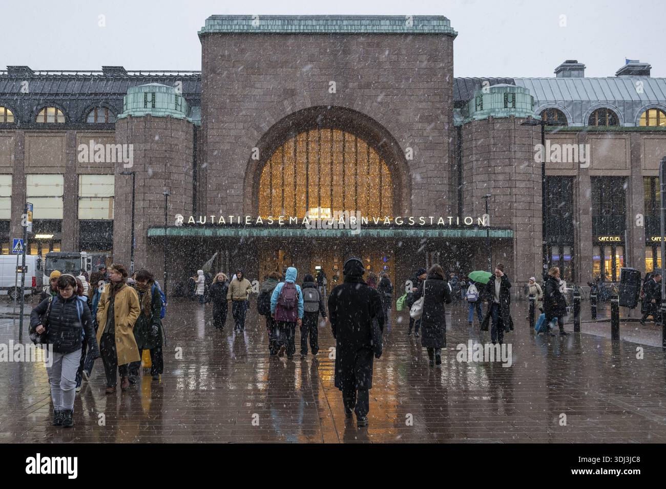 Ingresso laterale affollato alla stazione centrale con decorazioni natalizie durante le nevicate, Helsinki, Finlandia Foto Stock