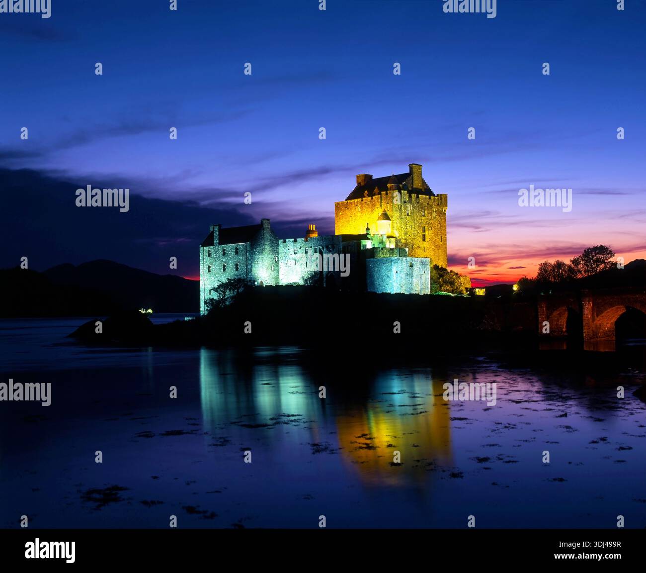 Una vista serale del castello di Eilean Donan mentre il sole tramonta nelle Highlands scozzesi. Foto Stock